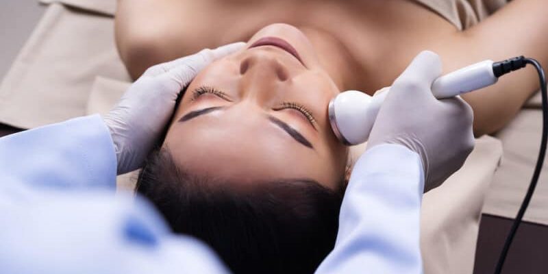 young woman receiving ultrasound facial beauty treatment skin care