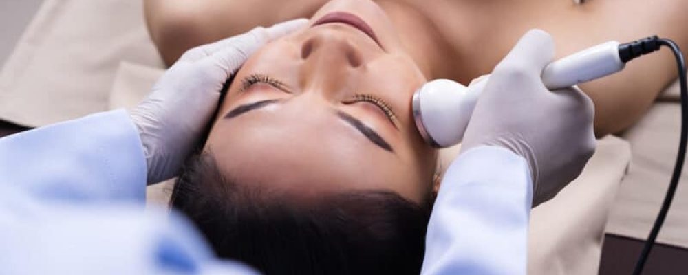 young woman receiving ultrasound facial beauty treatment skin care