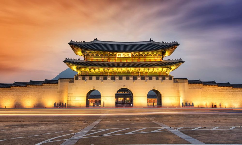 Gwanghwamun gate at Geyongbokgung Palace in Seoul at night. Long exposure image of traffic.